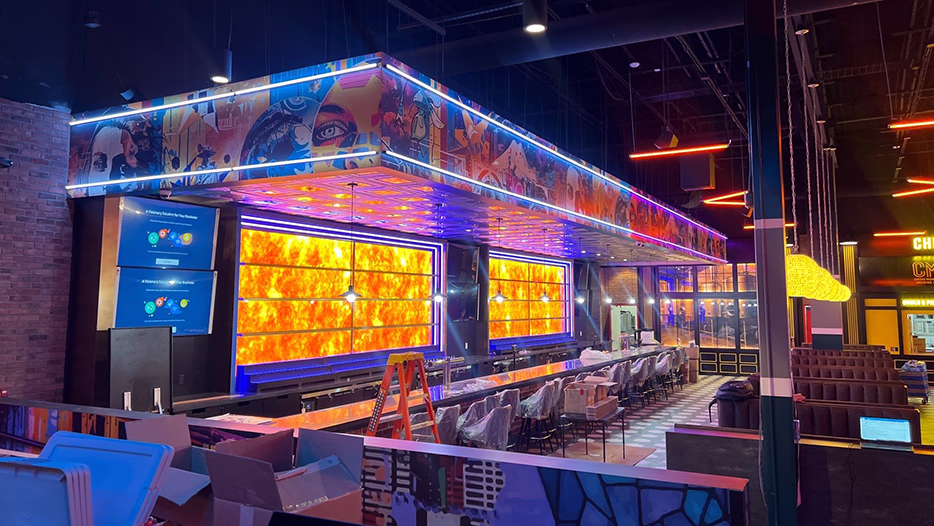 Modern Electric commercial restaurant and bar 
buildout with LED-lit panels, accent lighting, and digital menu screens